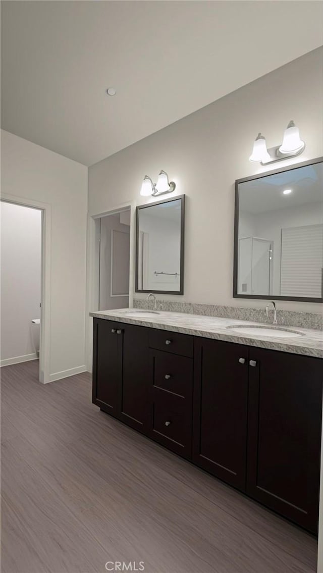 bathroom with vanity, toilet, and wood-type flooring