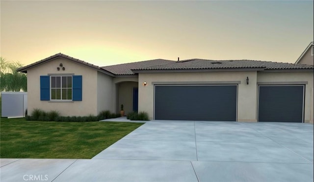 view of front of home featuring a garage and a lawn