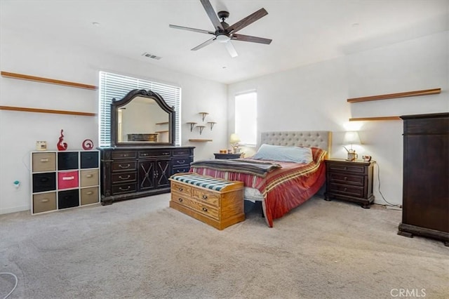 bedroom with light carpet, ceiling fan, and visible vents