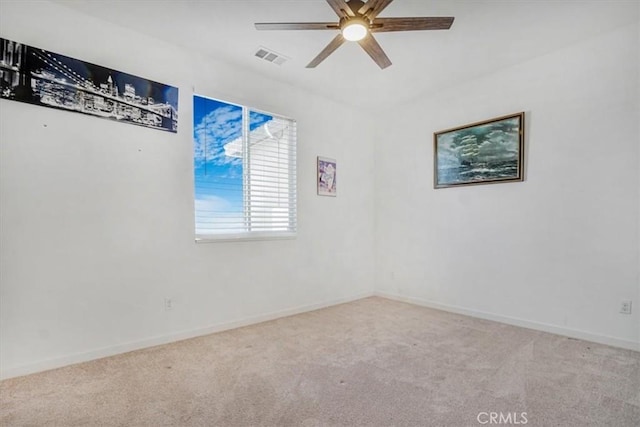 spare room featuring ceiling fan, visible vents, baseboards, and light colored carpet