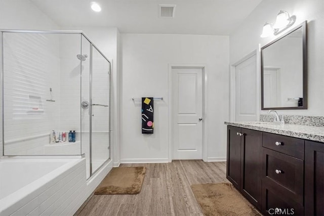 full bath with a garden tub, visible vents, a stall shower, vanity, and wood finished floors