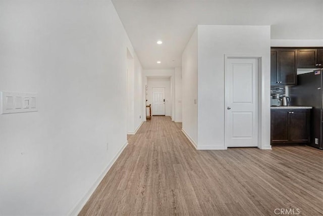 hall featuring recessed lighting, light wood-style flooring, and baseboards