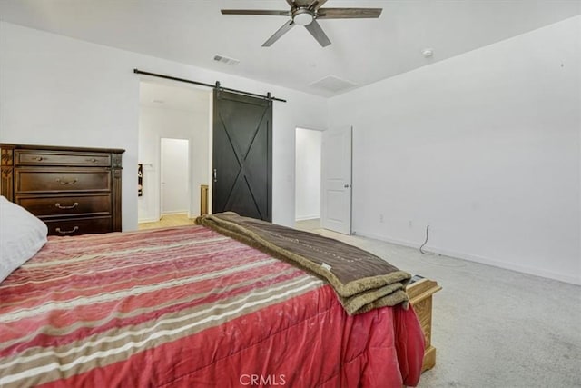 bedroom with ceiling fan, a barn door, light colored carpet, visible vents, and baseboards