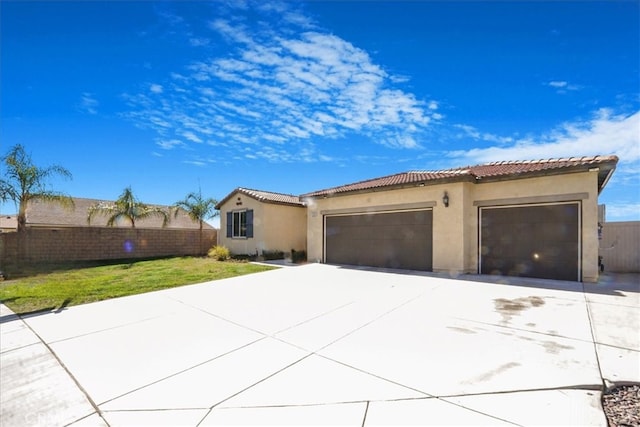 exterior space featuring a garage, fence, driveway, and stucco siding