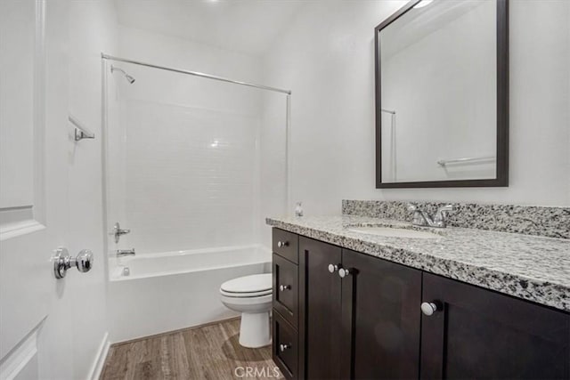 full bathroom featuring toilet, bathing tub / shower combination, wood finished floors, and vanity