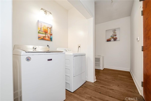 clothes washing area featuring dark hardwood / wood-style flooring and washing machine and dryer