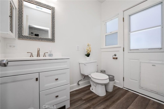 bathroom with wood-type flooring, vanity, and toilet