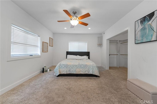 carpeted bedroom with multiple windows, a spacious closet, a closet, and ceiling fan