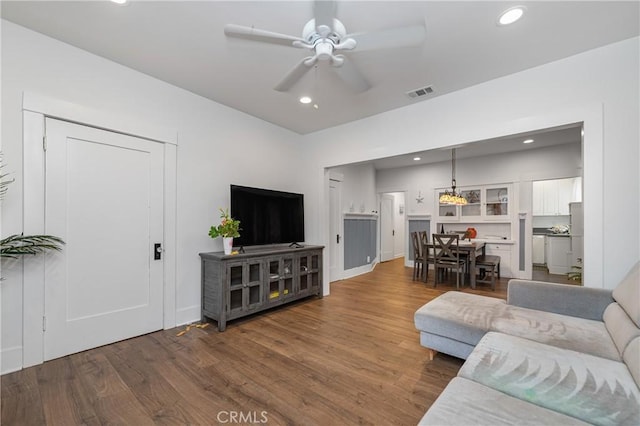 living room with dark wood-type flooring and ceiling fan