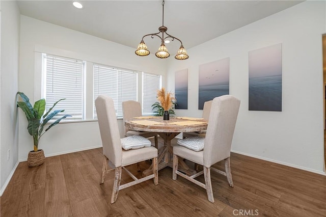 dining space featuring an inviting chandelier and hardwood / wood-style flooring