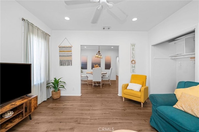 sitting room with wood-type flooring and ceiling fan