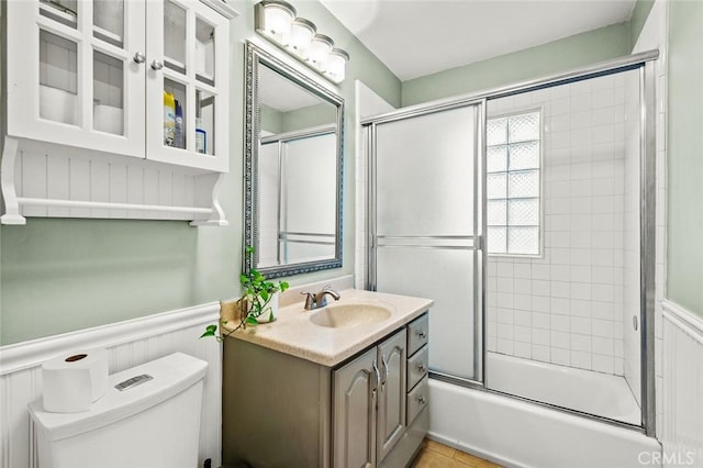 full bathroom with vanity, toilet, and combined bath / shower with glass door