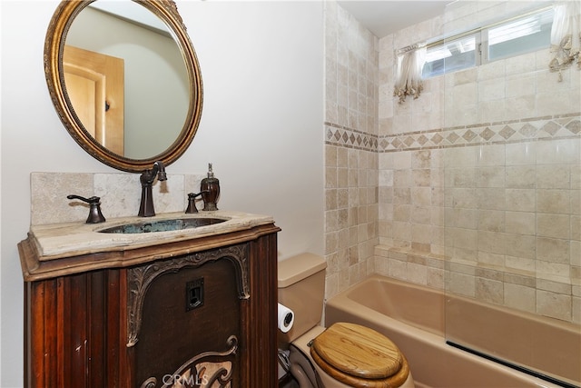 full bathroom with vanity, tiled shower / bath, and toilet