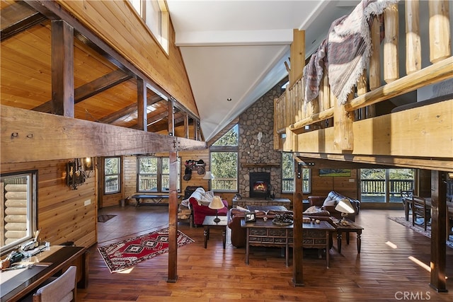 interior space with beamed ceiling, wood-type flooring, a fireplace, and wood walls