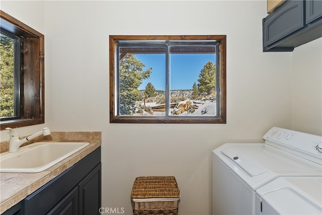 laundry room with cabinets, a healthy amount of sunlight, sink, and washer and clothes dryer