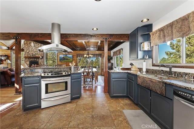 kitchen featuring sink, island range hood, appliances with stainless steel finishes, kitchen peninsula, and beamed ceiling