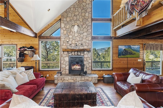 living room with a healthy amount of sunlight, high vaulted ceiling, and wood walls