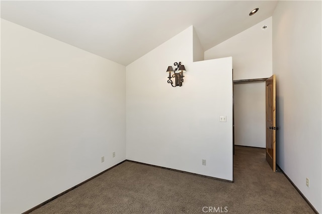 carpeted empty room with lofted ceiling