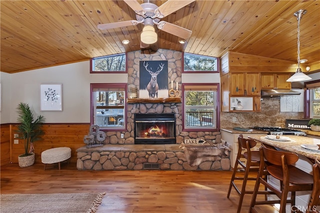 kitchen with decorative light fixtures, light hardwood / wood-style flooring, wooden ceiling, and stainless steel gas stovetop