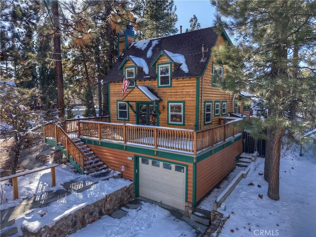 snow covered property with a garage