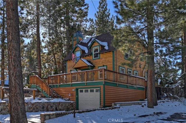 cabin featuring a wooden deck and a garage