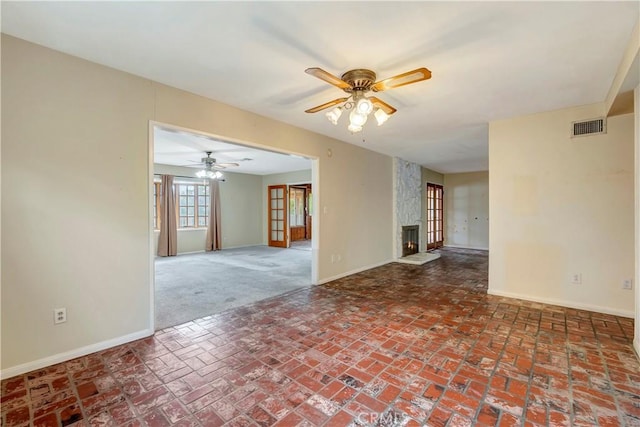 empty room featuring ceiling fan and a large fireplace