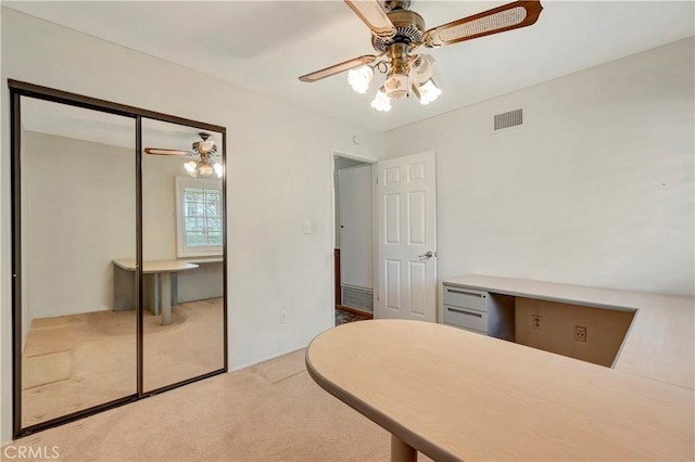 carpeted bedroom featuring ceiling fan and a closet