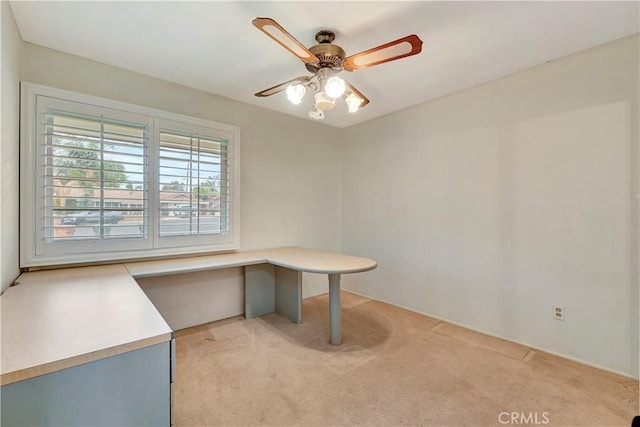 unfurnished office with ceiling fan and light colored carpet