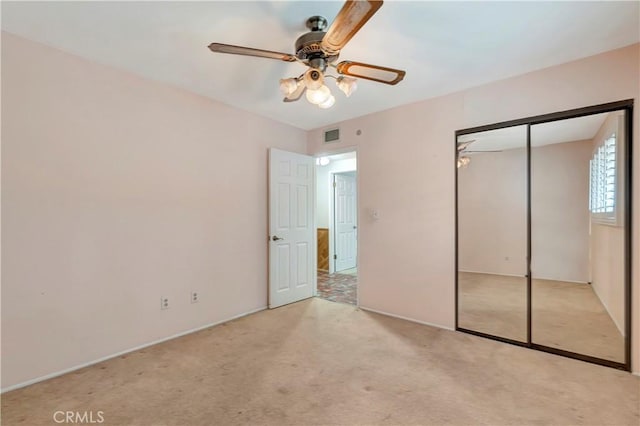 unfurnished bedroom with light colored carpet, a closet, and ceiling fan