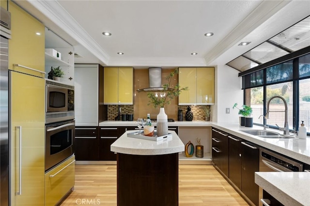 kitchen featuring appliances with stainless steel finishes, sink, wall chimney range hood, and dark brown cabinetry