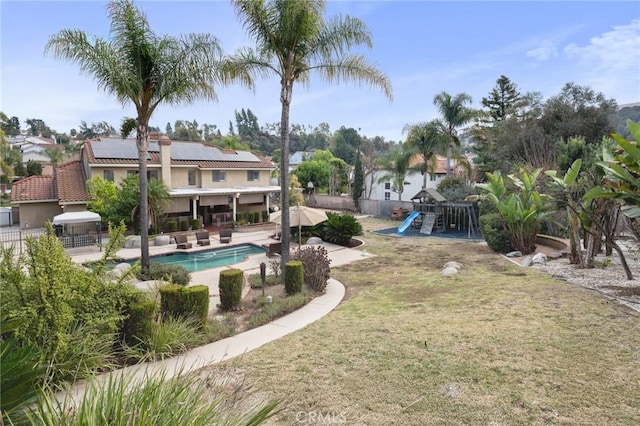 view of swimming pool with a lawn, a playground, and a patio area