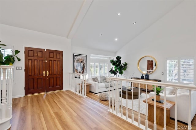 foyer with high vaulted ceiling and light hardwood / wood-style flooring