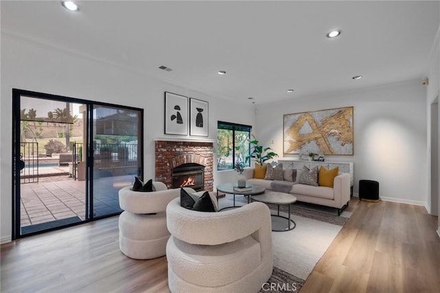 living room with a brick fireplace and light hardwood / wood-style flooring