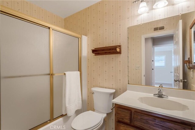 full bathroom with vanity, combined bath / shower with glass door, and toilet