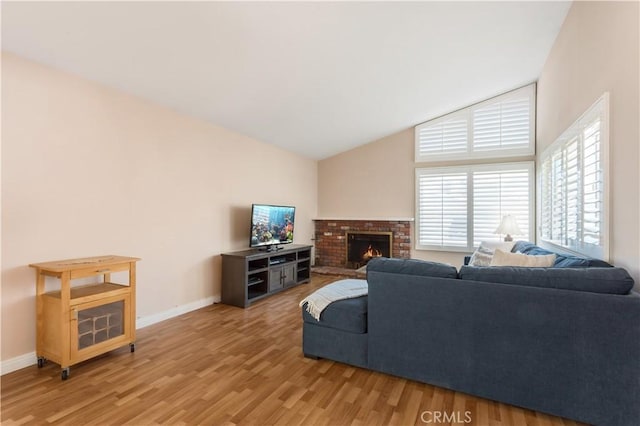 living room featuring vaulted ceiling, hardwood / wood-style floors, and a fireplace