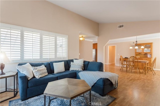 living room featuring crown molding, lofted ceiling, and hardwood / wood-style floors