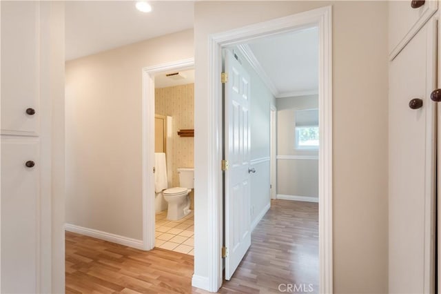 hallway featuring ornamental molding and light wood-type flooring