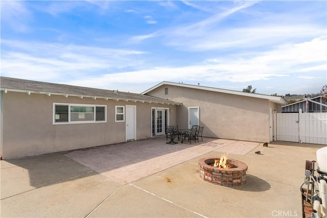 back of property featuring a patio area and a fire pit