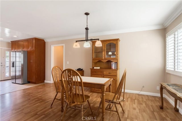 dining space featuring crown molding and light hardwood / wood-style floors