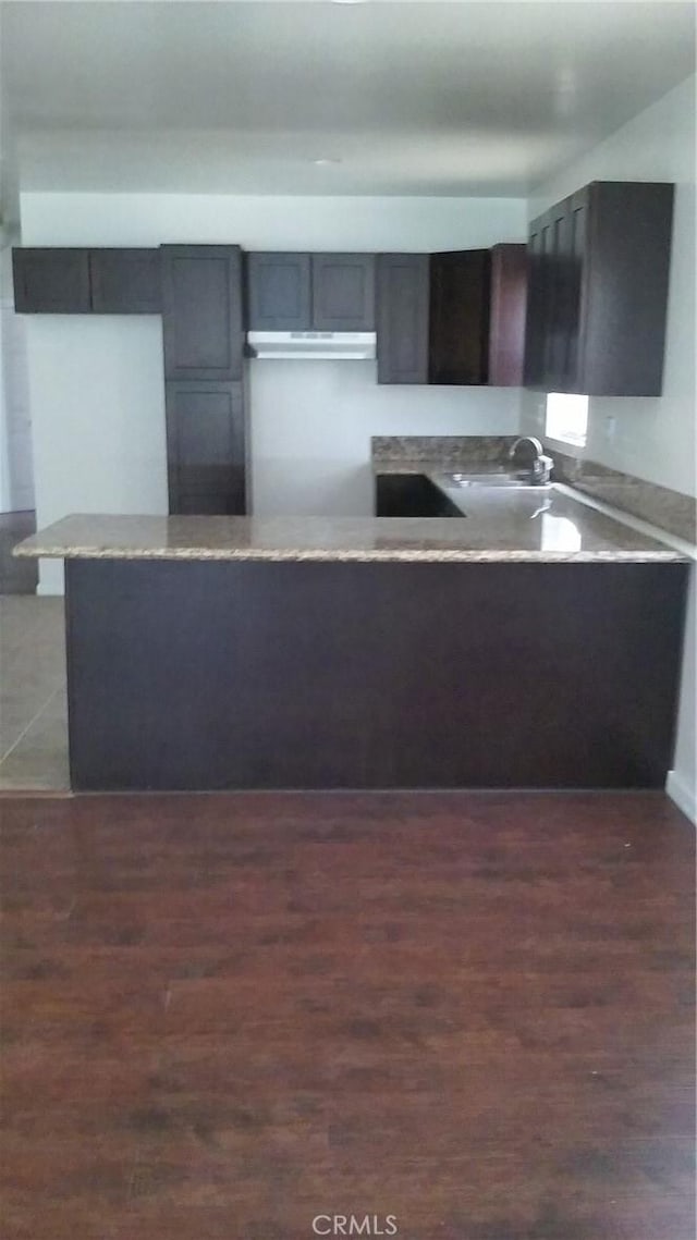 kitchen with sink, dark wood-type flooring, and kitchen peninsula