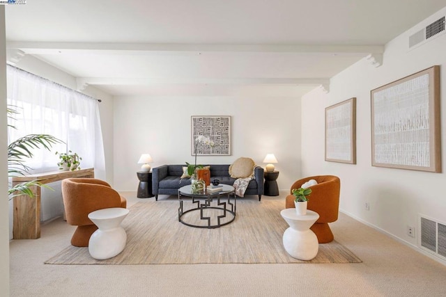 living room featuring beamed ceiling and light carpet