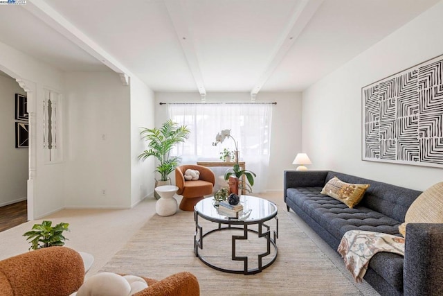 living room with beamed ceiling and light carpet