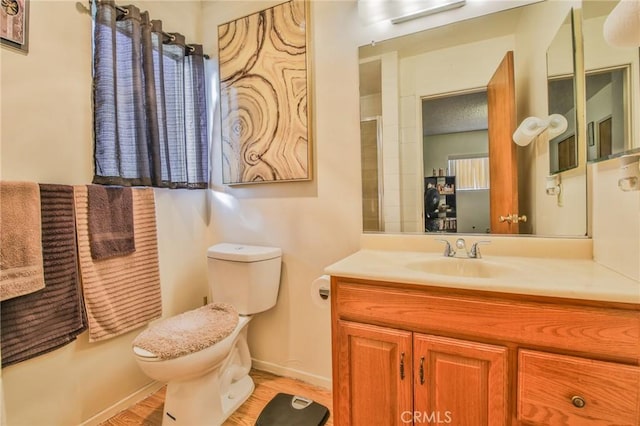 bathroom featuring hardwood / wood-style flooring, vanity, and toilet