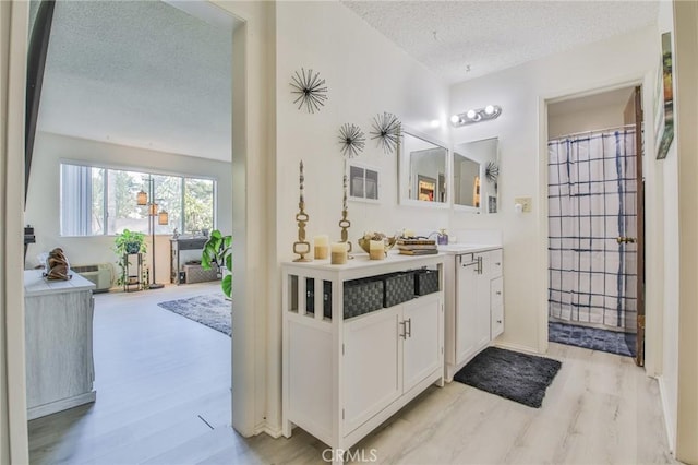 bathroom featuring wood-type flooring, a textured ceiling, and vanity