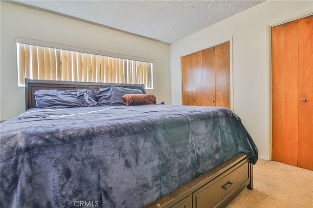 bedroom with light colored carpet, a closet, and a textured ceiling