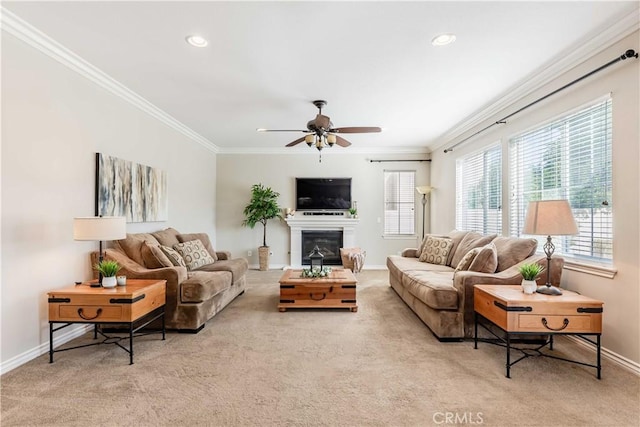 carpeted living room with ceiling fan and ornamental molding