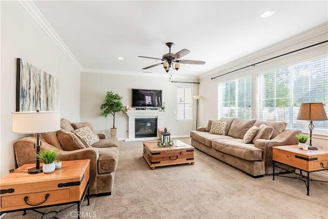 carpeted living room featuring ornamental molding and ceiling fan