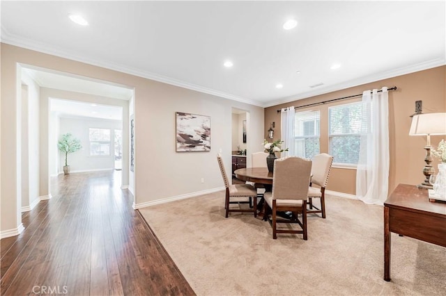 dining room with crown molding and light wood-type flooring