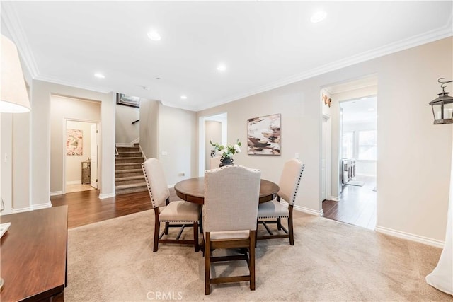 carpeted dining space with crown molding