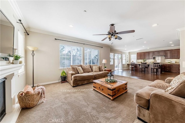 living room with ceiling fan and ornamental molding